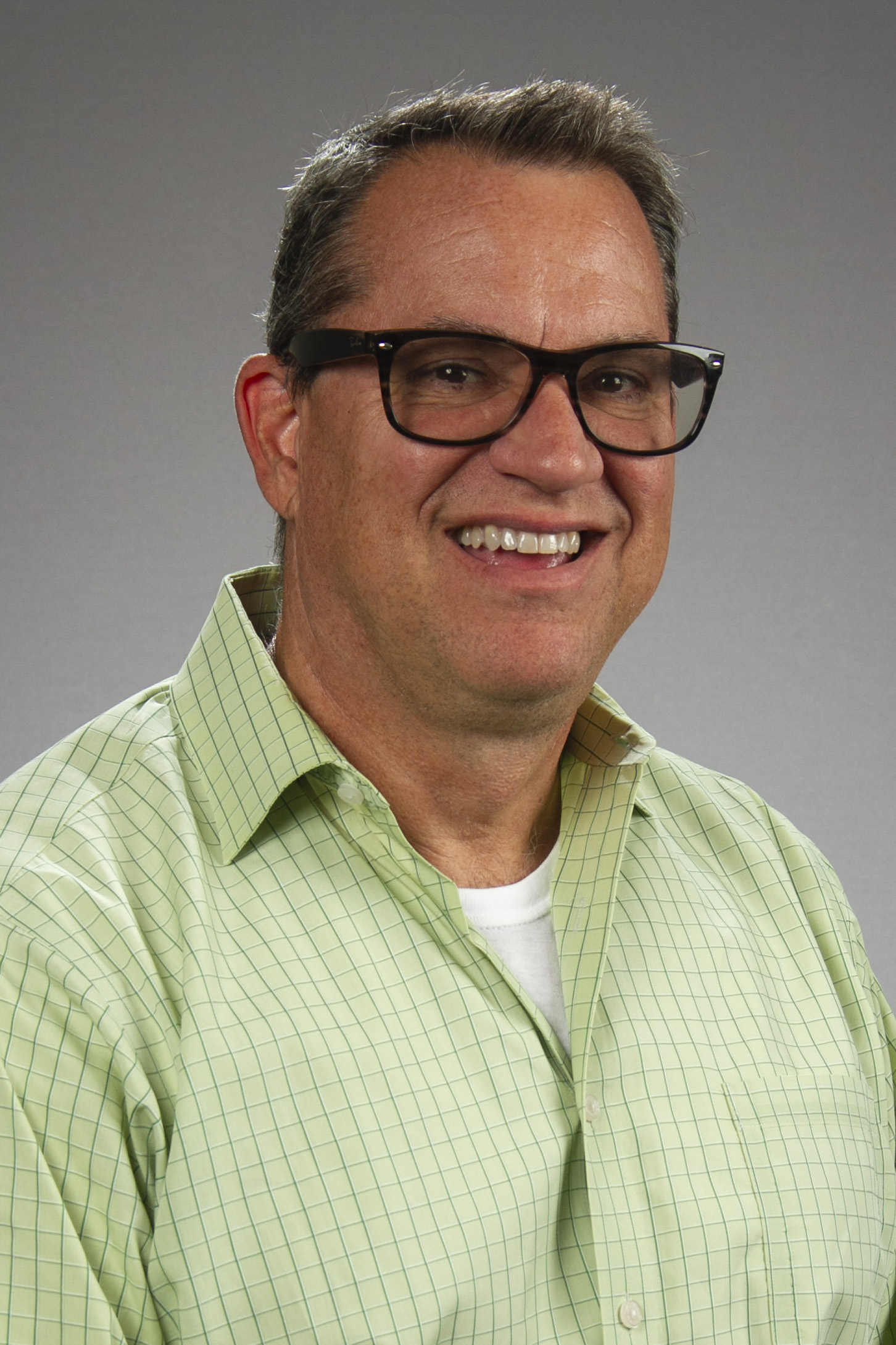 Man with dark hair, glasses, green shirt